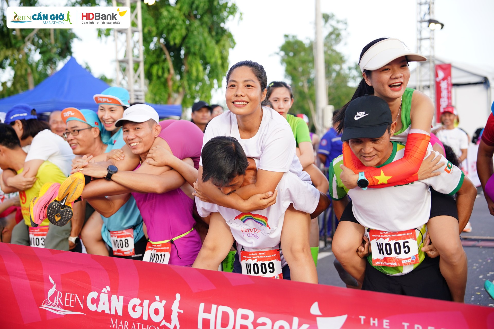 Chồng cõng vợ trên "đường đua xanh" Green Cần Giờ Marathon HDBank 2024 - hoạt động kết nối gia đình đáng nhớ- Ảnh 2.