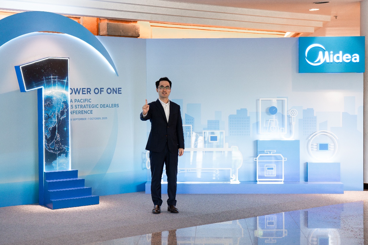 A person in a suit standing in front of a blue wall  AI-generated content may be incorrect.