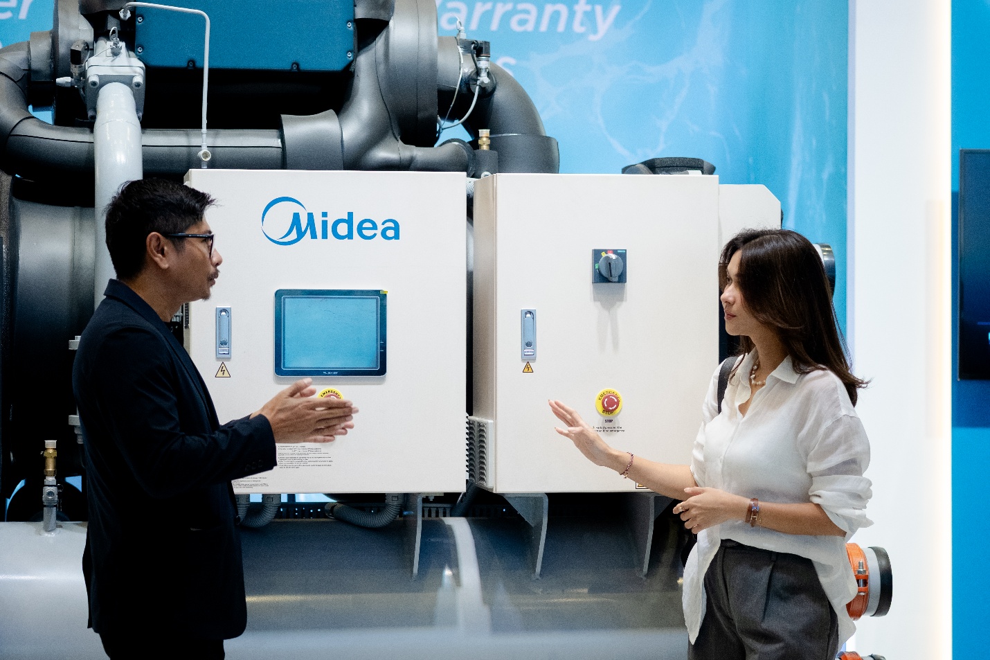 A person and person talking in front of a machine  AI-generated content may be incorrect.