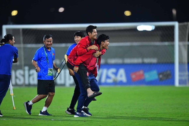 Ảnh: Xúc động khoảnh khắc Lý Đức cõng Hiểu Minh chấn thương, HLV Kim Sang-sik ăn mừng với cờ tổ quốc Việt Nam - Ảnh 1.