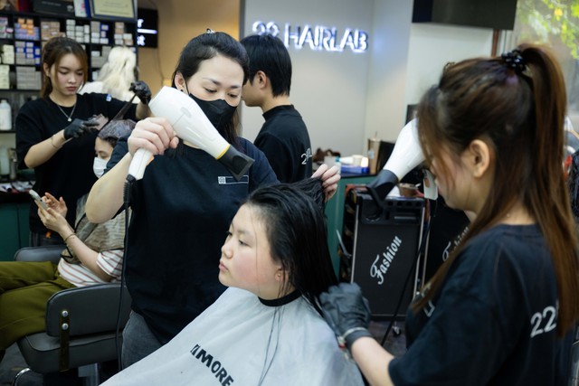 Salon tóc ngày 28 Tết: Khách xếp hàng nườm nượp, thợ làm hết công suất, kín lịch đến khuya- Ảnh 1.